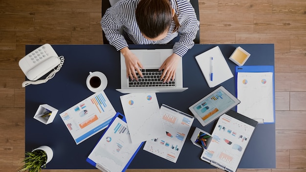 Top view of businesswoman sitting at desk table typing financial accounting company expertise