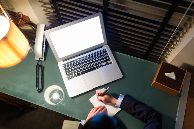 Top view of businesswoman taking note on the desk