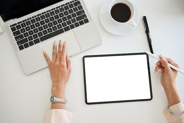 Top view of a businesswoman working at her desk using laptop and digital tablet tablet mockup