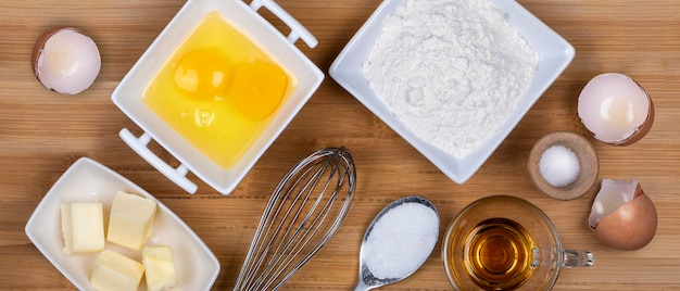 Top view on a butter, sugar, eggs, flour, salt and rome ingredients for cooking a cake