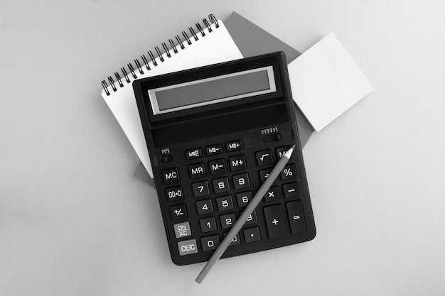 Top view of calculator pencil and notebook on the gray background Closeup Workspace desk