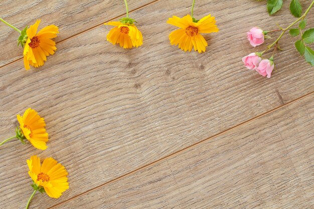 木の板にキンセンカとバラの花の上面図