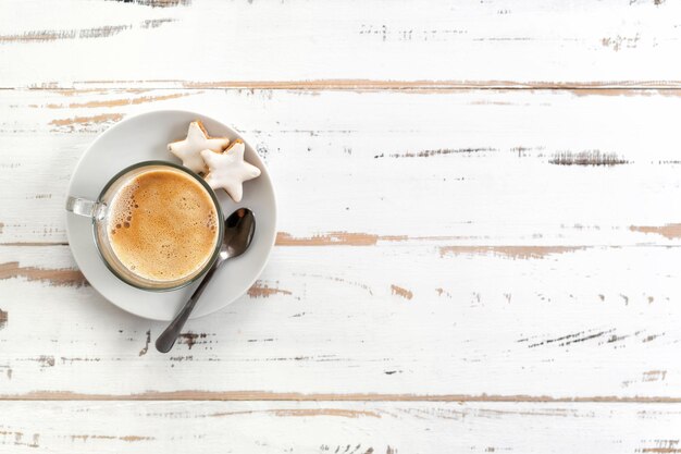 Top view of cappuccino cup on white wooden background Copy space