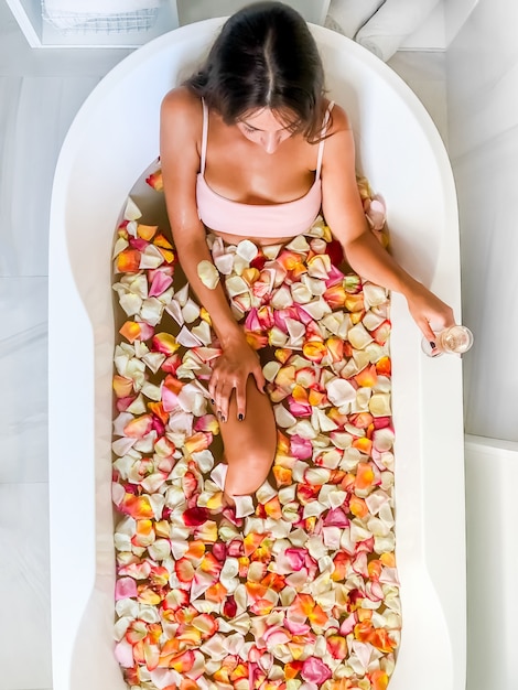 Photo top view of caucasian female in swimsuit sitting in bathtub with