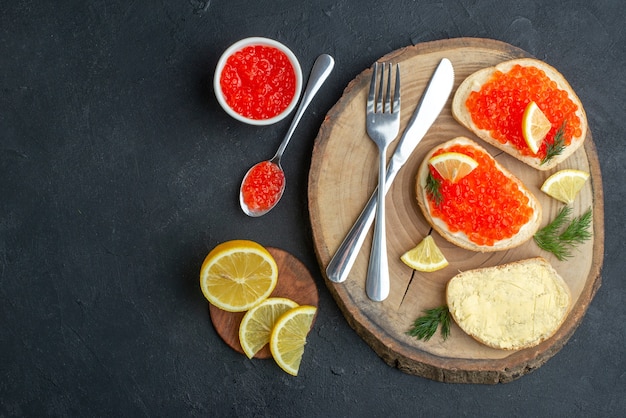 top view caviar sandwiches with cutlery on cutting board dark surface