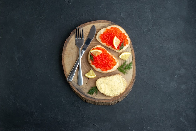 top view caviar sandwiches with cutlery on cutting board dark surface