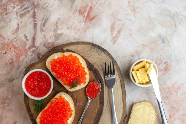 top view caviar sandwiches with cutlery on cutting board light surface