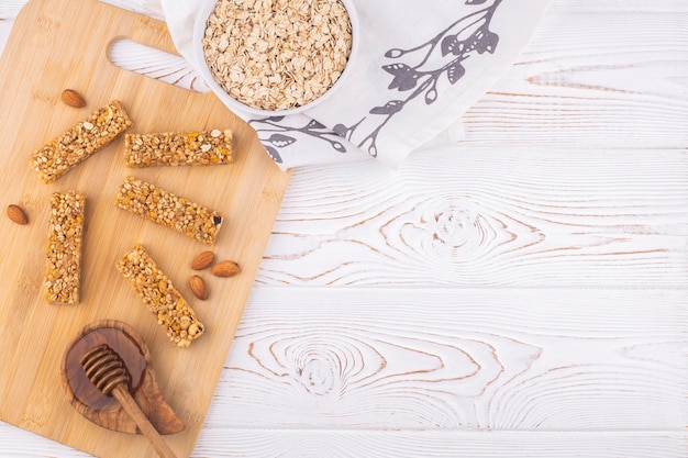 Top view of cereal muesli bar with nuts and honey on a white wooden table healthy sweet dessert snac