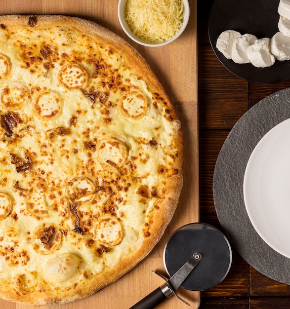 Top view cheese pizza on cutting board