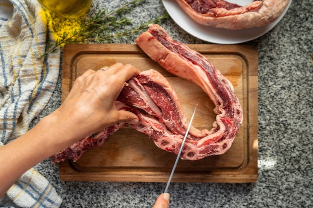 Vista dall'alto dello chef che taglia le costolette crude per cucinare un tipico asado argentino