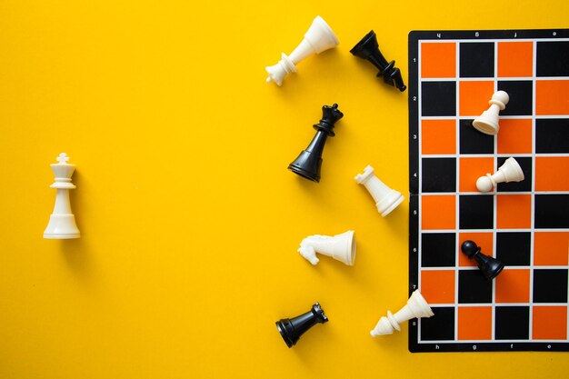 Photo top view chessboard on yellow background winner and loser