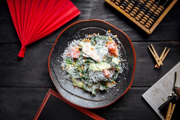 Top view of chicken salad with lettuce and pine nuts sprinkled with parmesan