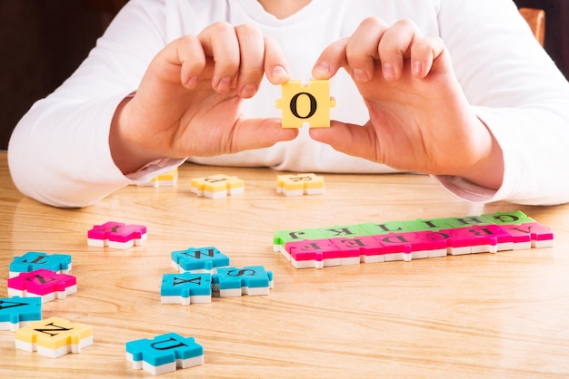 Photo top view of child arm learning alphabet with puzzlein the table copy space learning in the form of a game concept