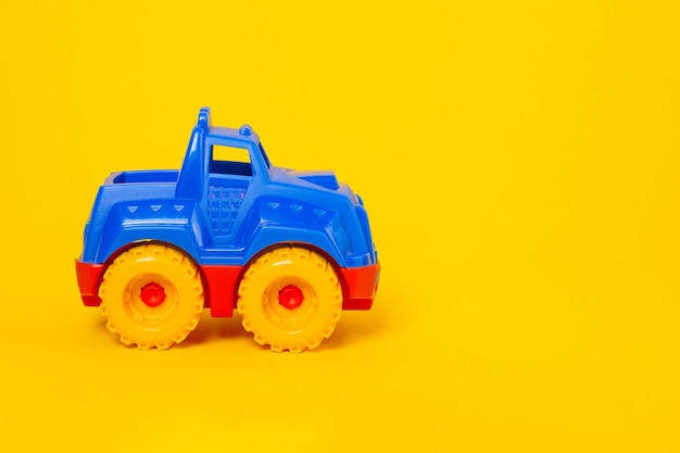 Top view children's toy car on a yellow background with copy space Flat lay baby toy redblue car