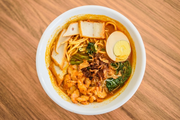 Top view of Chinese chopsticks eating noodle, a famous Malaysia prawn noodle curry soup.