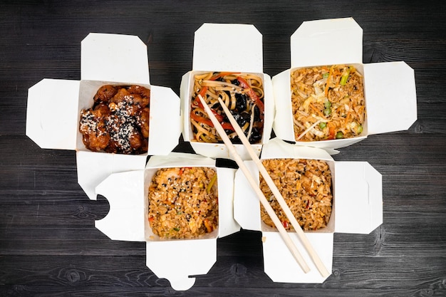 Photo top view of chinese fast food in disposable boxes