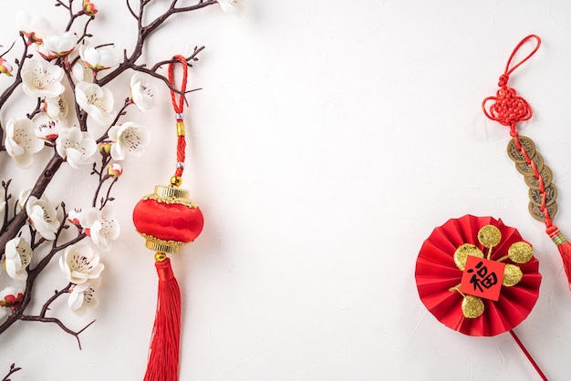 Photo top view of chinese lunar new year background copy space design concept with white plum flower and festive decoration, the word inside picture means blessing.