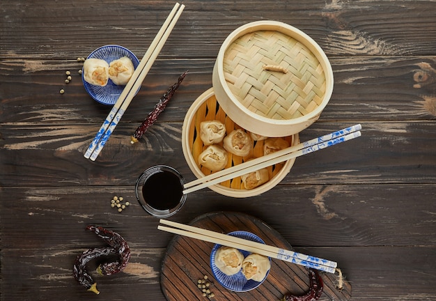 Top view of chinese meat dumpling steamed dish in bamboo steamer box with chopsticks