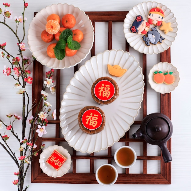 Top View Chinese New Year Cake (Chinese character "Fu" means Fortune). Popular as Kue Keranjang or Dodol China in Indonesia. Served with Cookies and Orange Imlek Red Decoration