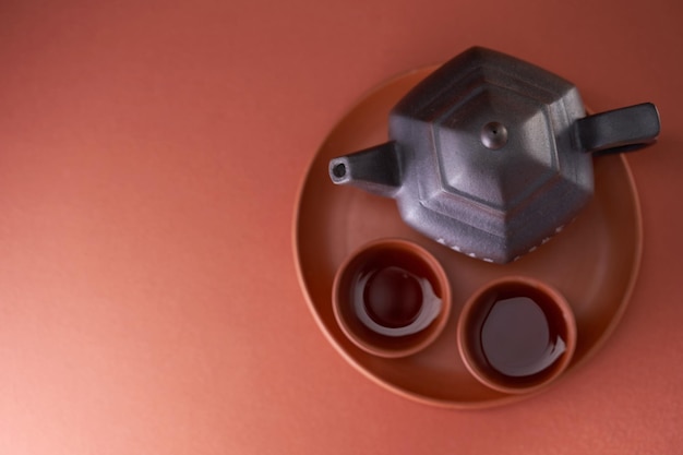 Top view chinese tea cup and teapot against red background