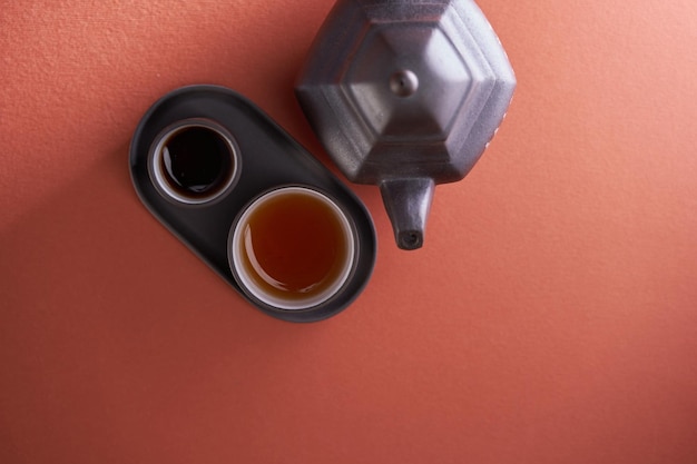 Top view chinese tea cup and teapot against red background