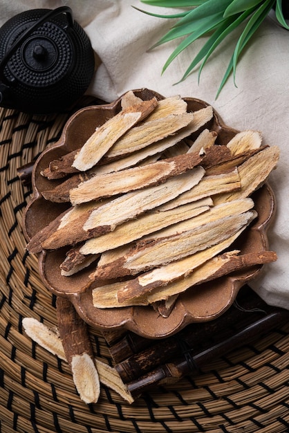 Top view of Chinese traditional herbal medicine Astragalus root on wooden table background.