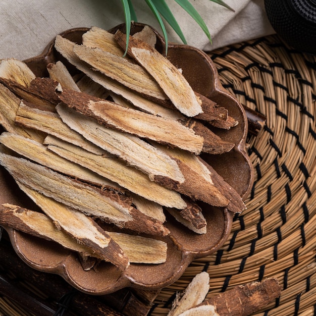 Top view of Chinese traditional herbal medicine Astragalus root on wooden table background.