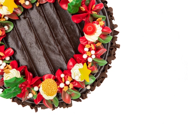 Top view of a chocolate chiristmas cake decorated with red and white flowers