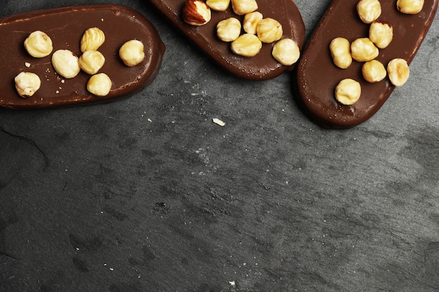 Vista dall'alto di gelati al cioccolato su uno sfondo di ardesia scuro con nocciole piatte