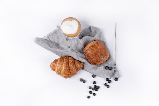 Top view of a chocolatine a croissant and some blueberries isolated on a white background