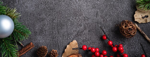 Top view of Christmas background design concept with fir tree branch, snowflake and pine cones.