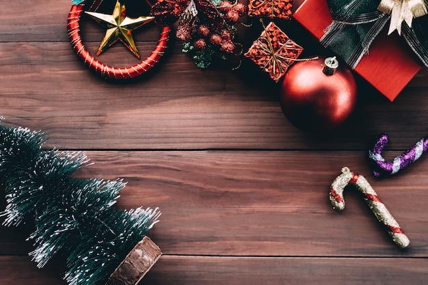 Top view of Christmas background with ornaments and gift boxes on the old wooden board.