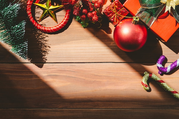 Foto vista dall'alto di sfondo di natale con ornamenti e scatole regalo sul bordo di legno vecchio.