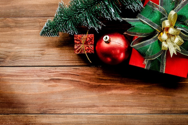 Top view of Christmas background with ornaments and gift boxes on the old wooden board.