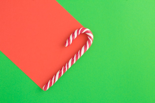 Top view of christmas caramel cane on the red green surface