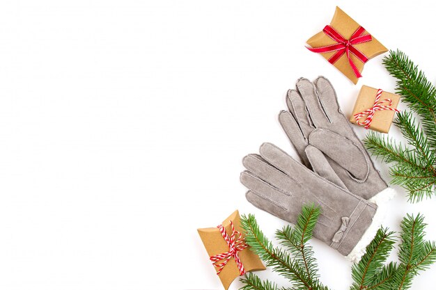 Top view over Christmas composition with gifts, xmas tree, and warm winter gloves.