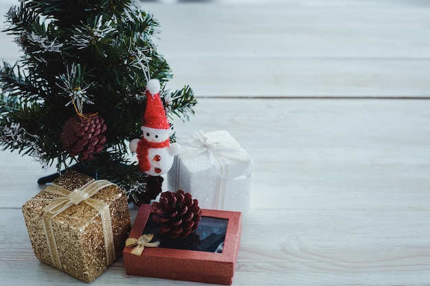 Top view of Christmas composition with tree, gift boxes, snow doll on wooden background and copy space. Accessories of Christmas and new year concept.