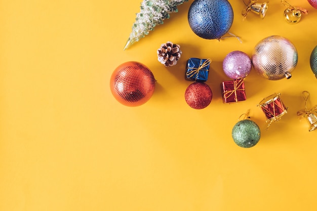 Top view of Christmas decorations on a yellow background. Free space for text