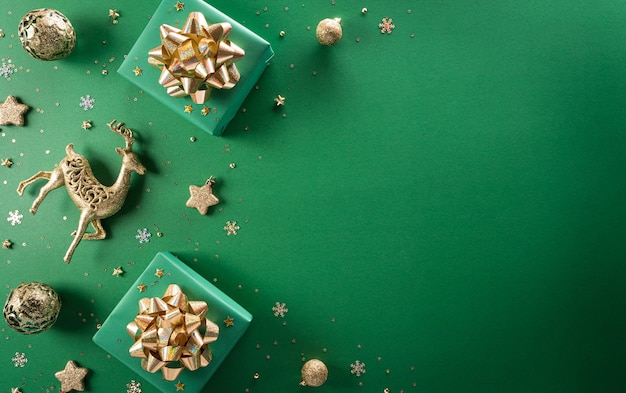 Top view of Christmas gift box christmas ball and snowflake on green background