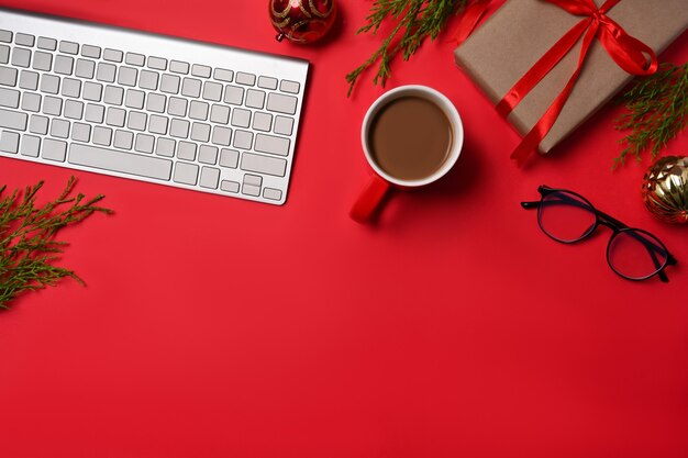 Top view Christmas gift boxes and coffee cup on red background.