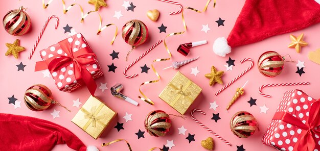 Top view of Christmas and new year decorations with confetti on pink