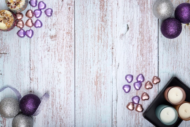 Top view of Christmas ornaments and scented candles on wooden background