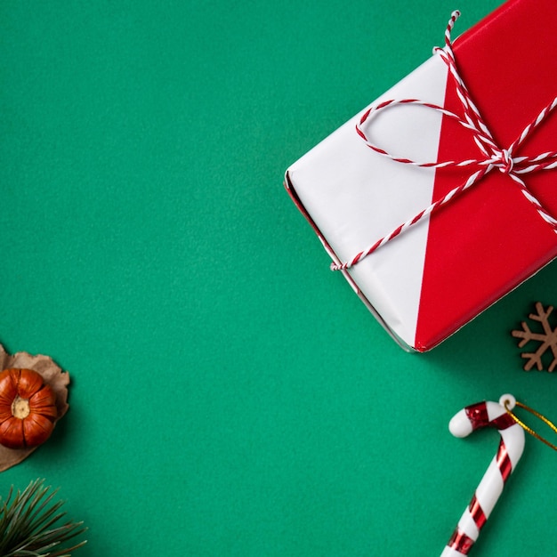 Photo top view of christmas shopping design concept with gift box and shopping cart on green table background