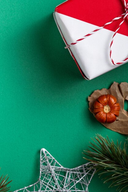 Вид сверху концепции дизайна рождественских покупок с подарочной коробкой и тележкой на зеленом фоне стола