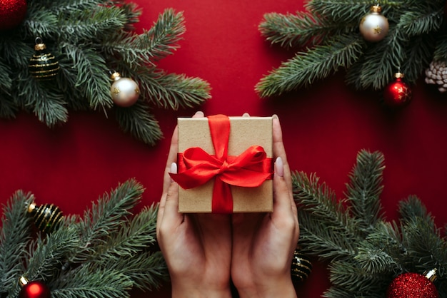 Top view of christmas tree branches with ornaments and gift