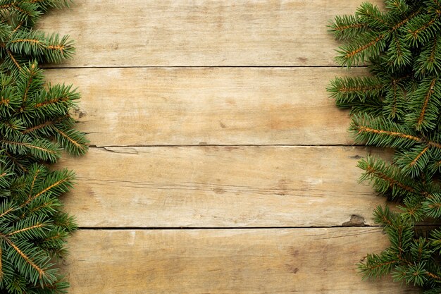 top view Christmas tree branches on wooden table