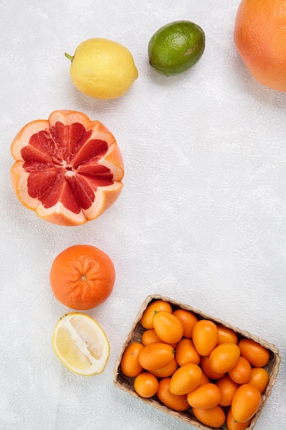 Top view of citrus fruits as grapefruit tangerine kumquats lime lemon orange on white background