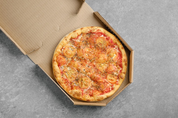 Top view of classic pizza margherita in cardboard box