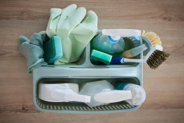 위생을 위해 집 거실에 있는 탁자에 있는 청소 제품과 바구니의 상위 뷰 먼지 세균이나 박테리아를 소독하거나 제거하기 위한 봄 청소 건강 또는 가사 장비 도구 또는 용품