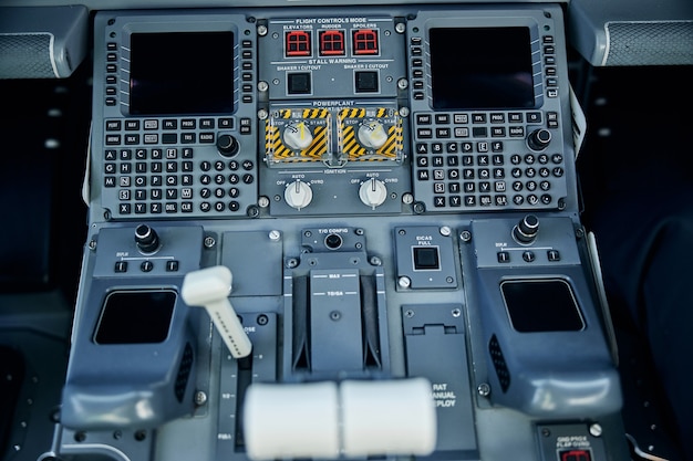 Foto vista dall'alto primo piano delle apparecchiature di controllo con schermi digitali e leve per l'aereo volante